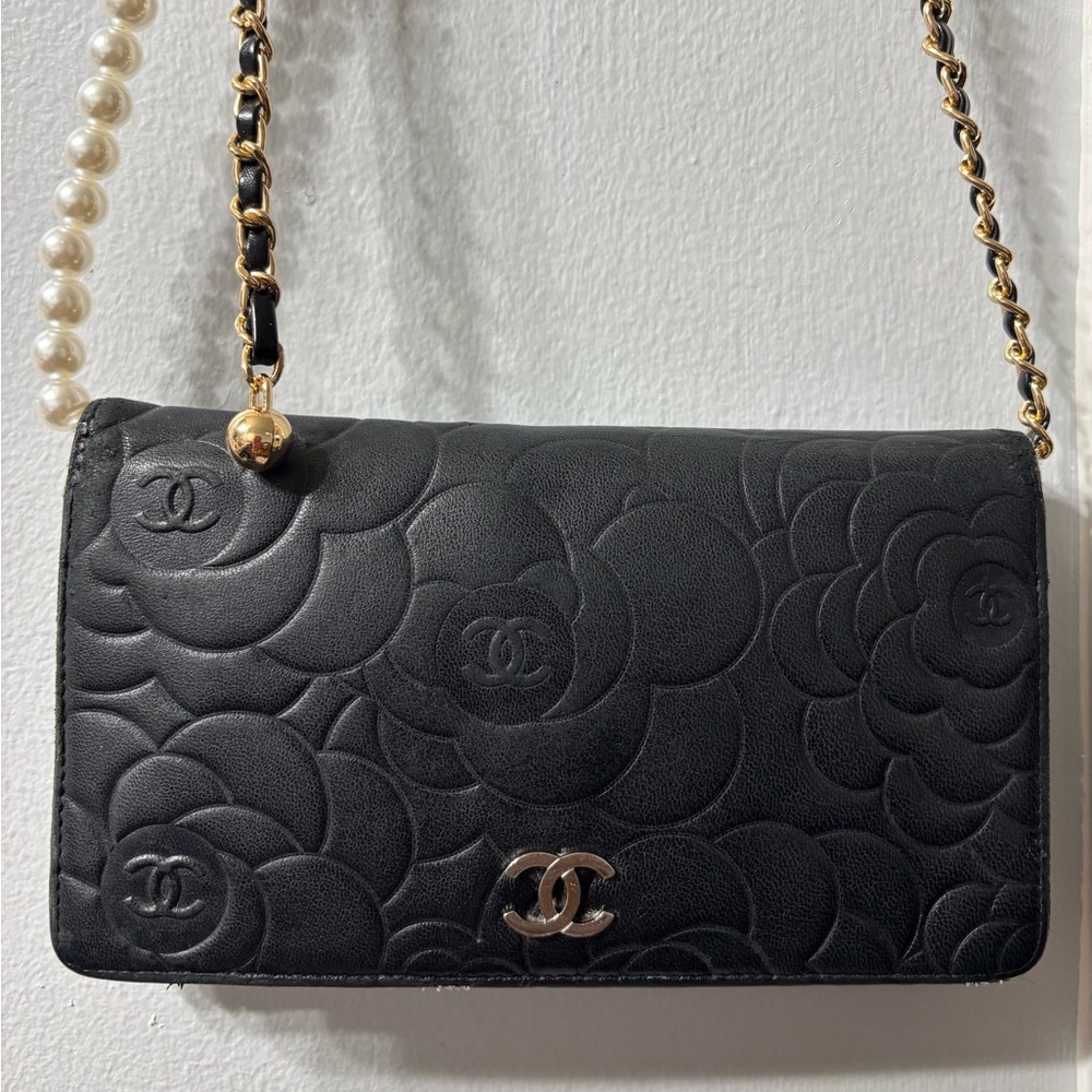 CHANEL Authentic Lambskin Camellia
Embossed Yen Wallet in Black.